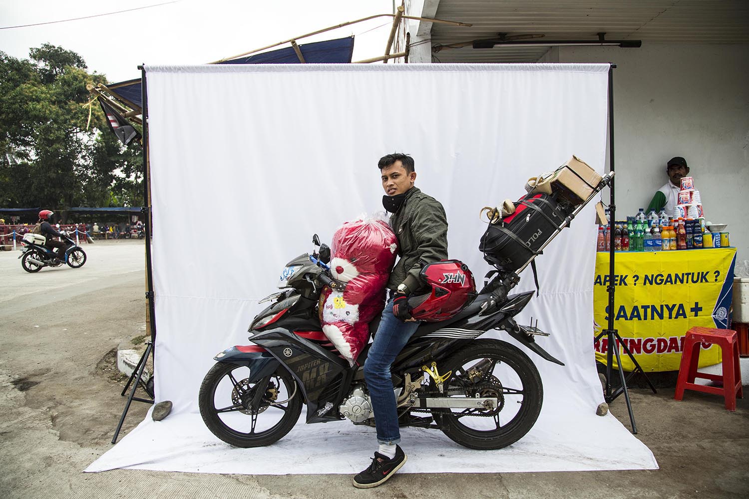 Pemudik motor Cahyo, tujuan Tegal, Jawa Tengah di SPBU Ciasem, Sukamandi, Subang, Jawa Barat, Minggu (12/7/2015). Menggunakan motor, mudik membawa pakaian lebaran dan oleh-oleh untuk sanak saudara dan pacarnya di kampung halaman. MI/RAMDANI MEREKA YANG MENERJANG ANGINJelang Idul Fitri, bagi sebagian orang, pulang bukan lagi pilihan. Ya, pulang kembali ke orang-orang terkasih di kampung halaman merupakan ritual ‘wajib’ yang mesti dilakoni, bagaimanapun caranya, apa pun risikonya. Itulah yang dilakoni sebagian pemudik bermotor. Terpaan angin, rasa lelah, dan kantuk, belum lagi risiko tersambar kendaraan besar, harus siap mereka hadapi. Lalu Marzuki ialah salah satu diantara ribuan pemudik yang nekat menggunakan moda transportasi ini. Saat ditemui di stasiun pengisian bahan bakar umum di Sukamandi, Ciasem, Subang, Jawa Barat, Sabtu (11/7/2015), dia mengaku baru pertama kali mudik naik kuda besi ini. Kali ini, Zuki mengajak istri dan anaknya, serta beberapa barang bawaan. Tujuannya lumayan jauh, Lombok, Nusa Tenggara Barat. Itu artinya, dia baru menempuh sepersekian kilometer dari total ribuan kilometer perjalanannya dari Jakarta. “Kalau mau enak tinggal naik angkutan umum, kalau mau murah tinggal ikut mudikgratis, sekarang gampang kan.Namun, bukan itu. Kebetul anak istri saya suka travelling dan berpetualang, makanya kami enggak masalah mudik ke Lombok menggunakan motor,” tutur Zuki tentang aksi nekatnya itu.“Nikmati perjalanannya saja. Kalau capek, ya, istirahat. Enggak usah dipaksa, tidur dimana saja sedapatnya, perjalanan dua hari satu malam enggak bakal berasa, dan yang pasti kita punya banyak cerita,” imbuhnya. Zuki tentu saja tak sendiri. Pemudik lainnya, bahkan mengaku sudah sejak 2002 pulang ke kampungnya di Tegal, Jawa Tengah, naik motor. Mudik memang telah menjadi tradisi tahunan bagi masyarakat Indonesia, khususnya jelang Idul Fitri. Orang berbondong-bondong dengan berbagai macam bawaan pulang ke kampung halaman demi berlebaran bersama keluarga